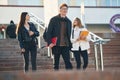 Walking down the stairs. Three young students are outside the university outdoors Royalty Free Stock Photo