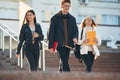 Walking down the stairs. Three young students are outside the university outdoors Royalty Free Stock Photo