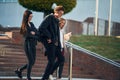 Walking down the stairs. Three young students are outside the university outdoors Royalty Free Stock Photo