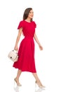 Walking Fashionable Woman In Red Dress, Gold High Heels And Beige Purse Royalty Free Stock Photo