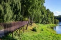 Walking footbridge laid between the trees growing near the reservoir