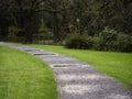 Walking footpath with puddles after rain in a park with rich green grass and trees. Fall autumn season concept Royalty Free Stock Photo