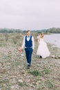 The walking groom along the baeach at the blurred background of the bride. Royalty Free Stock Photo