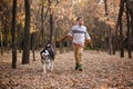 Walking the husky dog in the autumn park