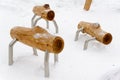 Walking logs. Interesting benches in the form of unusual animals made of wood in the snow. Benches in the form of sheep. Royalty Free Stock Photo