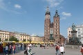 Walking in main square in Poland, with Towers of St. Mary's Basilica and Adam Mickiewicz Monument