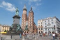 Walking in main square in Poland, with Towers of St. Mary's Basilica and Adam Mickiewicz Monument