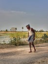 Walking man in our village lake side rode in evening .