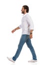 Walking Man In White Shirt, Jeans And Sneakers. Side View Royalty Free Stock Photo