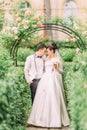 The walking newlyweds in the lovely garden. Full-length view. Royalty Free Stock Photo