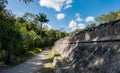 Walking path along ancient stone wall among Mayan ruins of Chichen Itza in Mexico Royalty Free Stock Photo