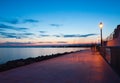 A walking path along the seaside with only shadows of people, walking in the evening Royalty Free Stock Photo