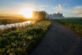 Walking path between fields by a river during a golden hour Royalty Free Stock Photo