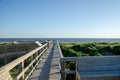 Wooden foot path over the sand dunes at the beach on a sunny day. Royalty Free Stock Photo