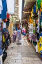 Walking people in ancient Old Town Market of Jerusalem full of shops with all kinds of touristic products like t-shirts, souvenirs Royalty Free Stock Photo