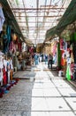 Walking people in ancient Old Town Market of Jerusalem full of shops with all kinds of touristic products like t-shirts, souvenirs Royalty Free Stock Photo