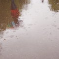 Walking people, reflection in the wet asphalt - vintage effect. Royalty Free Stock Photo