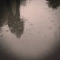 Walking people, reflection in the wet asphalt - vintage effect. Royalty Free Stock Photo