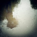 Walking people, reflection in the wet asphalt - vintage effect. Royalty Free Stock Photo