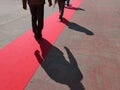 Walking persons on red carpet close view on legs