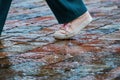 walking through a puddle in the rain. a passerby\'s foot on the paving stones Royalty Free Stock Photo