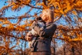 Walking pug dog in autumn park. Happy woman hugging and kissing pet Royalty Free Stock Photo