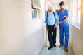 Walking the road to recovery together. a young doctor helping his senior patient walk down a hallway in hospital. Royalty Free Stock Photo