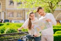 Woman sitting on bicycle and man with map standing nearby. Royalty Free Stock Photo