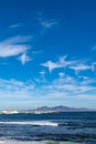 Walking on sea promenade in Corralejo along black rocks, blue water, view on Lanzarote island, Fuerteventura, Canary islands, Royalty Free Stock Photo