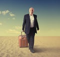 Walking senior man with suitcase in a desert