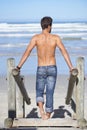 Walking, shirtless and back of man at the beach on tropical vacation, adventure or holiday. Travel, stairs and confident Royalty Free Stock Photo