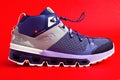 walking shoes or Swiss brand QC sneakers on a red background. Sports shoes. Stability and shock absorption of the sole