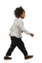 Walking small black boy in elegant clothes. Side view. Full length, isolated