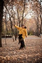 Walking the small black dog in the autumn park Royalty Free Stock Photo