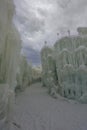 Walking on a snow path next to an ice wall and a large ice sculpture created from water and icicles at the Ice Castle show