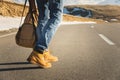 Walking on the summer sunset on the asphalt, men`s legs in yellow shoes and blue jeans go along the asphalt. Next to the Royalty Free Stock Photo