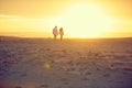 Walking into the sunset. Rearview shot of an affectionate mature couple walking hand in hand on the beach. Royalty Free Stock Photo