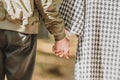 Cropped rear view of young couple holding hands, walking in park during autumn. Royalty Free Stock Photo