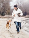 Walking together : girl with beagle dog runs along the autumnal sand beach