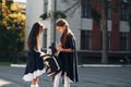 Walking together. Two schoolgirls is outside near school building Royalty Free Stock Photo