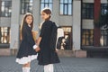 Walking together. Two schoolgirls is outside near school building Royalty Free Stock Photo