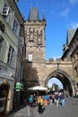 The walking tourists pass through an acre and come to Karlov Bridge.