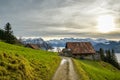 Walking trail leading to small farm with beautiful view on snowy Alps Royalty Free Stock Photo