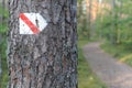 Walking trail marks and signs on trees showing direction for hikers in forest Royalty Free Stock Photo