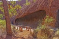 Walking trek in front of Men`s Cave which is of several shallow cave at the base of Uluru or Ayers Rock.