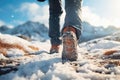 Walking in winter. Winter active recreation in the mountains, winter shoes. Male legs in winter boots close-up
