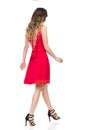Walking Woman In High Heels And Red Dress. Rear Side View. Royalty Free Stock Photo