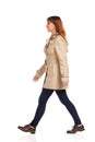 Walking Young Woman In Beige Coat, Jeans And Brown Shoes Royalty Free Stock Photo