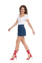 Walking Young Woman In Jeans Mini Skirt And Red High Heels. Side View Royalty Free Stock Photo