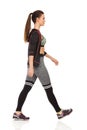 Walking Young Woman In Sports Clothes And Striped Leggings. Side View. Royalty Free Stock Photo